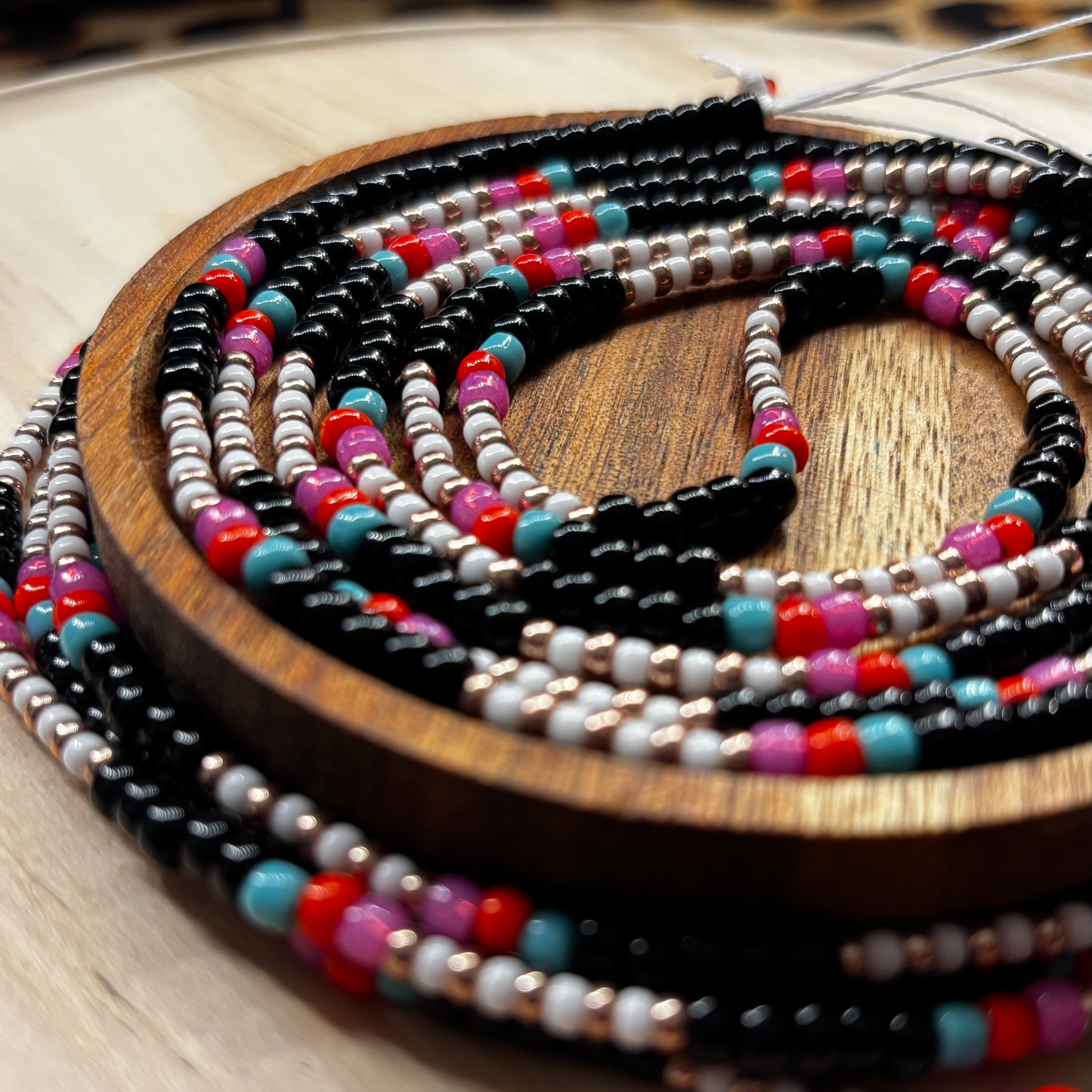 Colorful beaded necklaces on a wooden surface