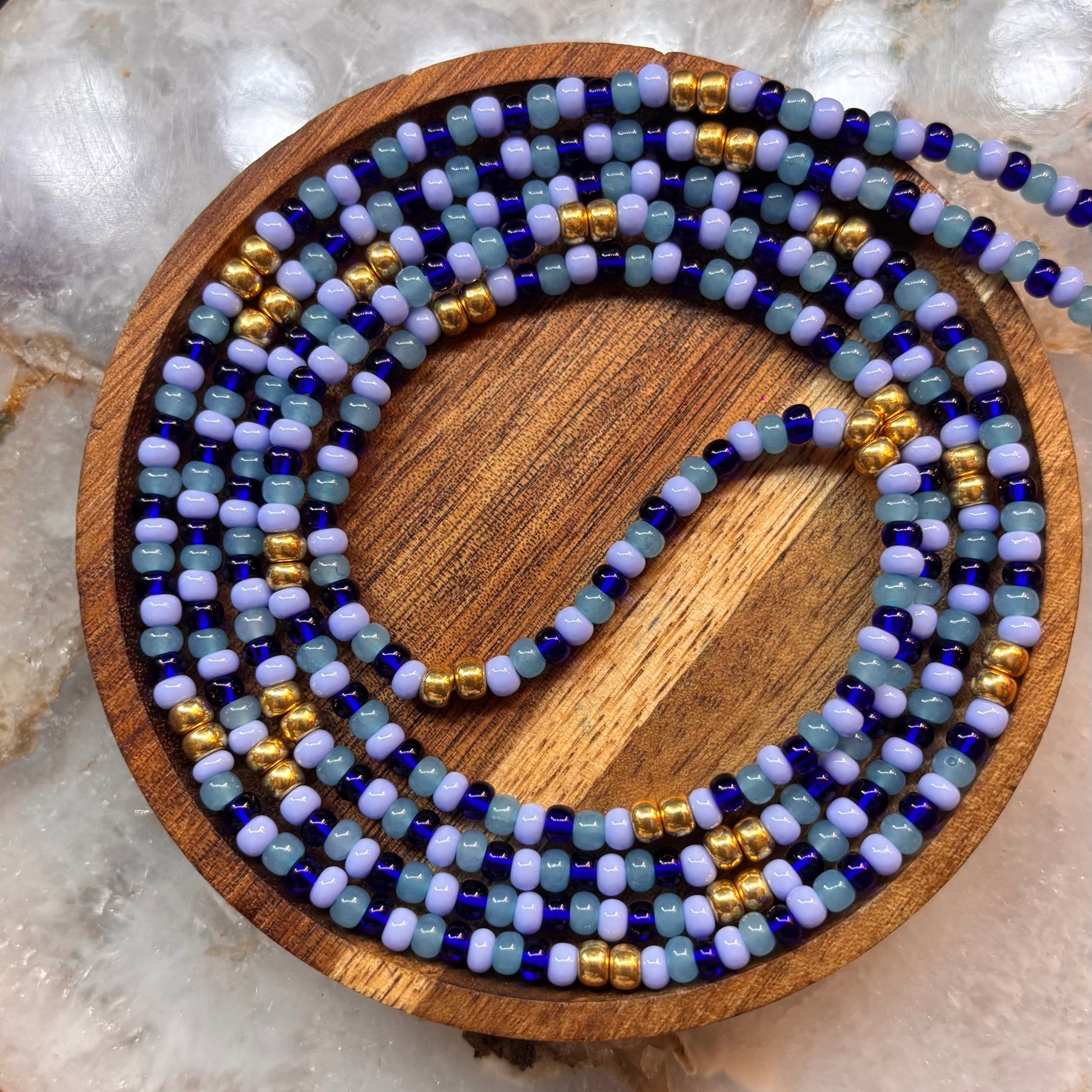 Handmade Blue Essence waist beads with blue Czech glass seed beads, gold spacers, and a delicate, flowing pattern for everyday wear.
