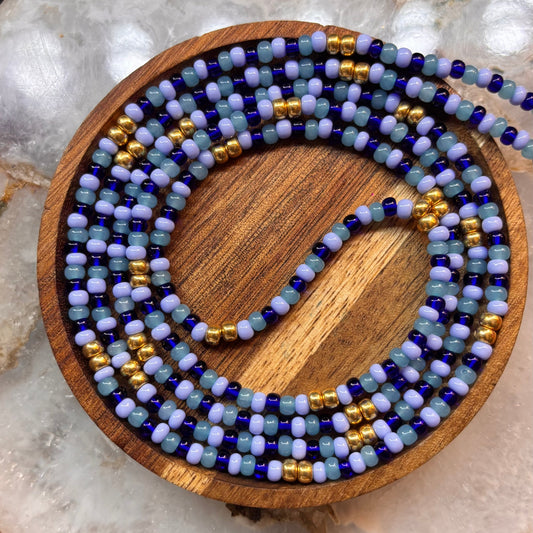 Handmade Blue Essence waist beads with blue Czech glass seed beads, gold spacers, and a delicate, flowing pattern for everyday wear.