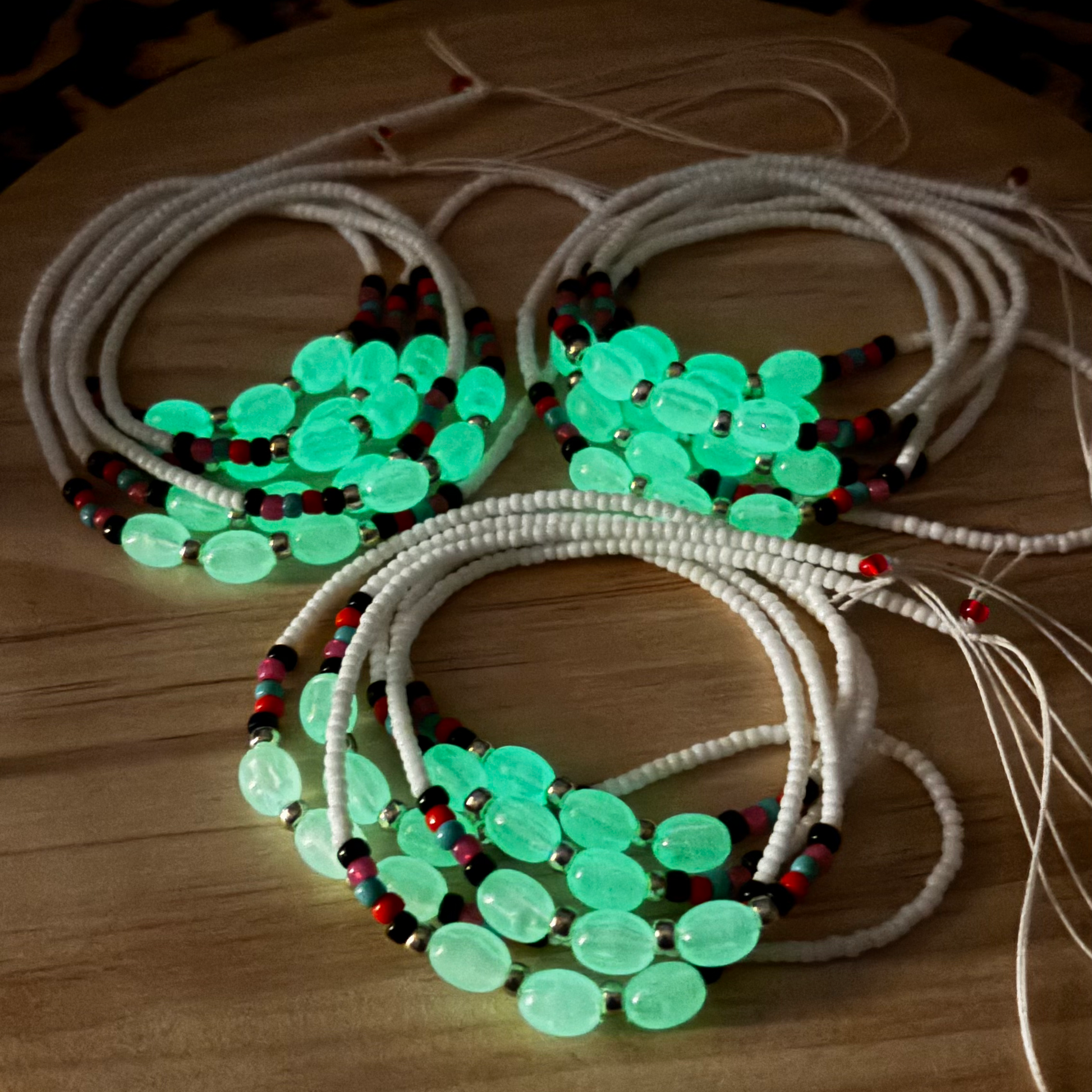 Necklaces with green beads on a wooden surface