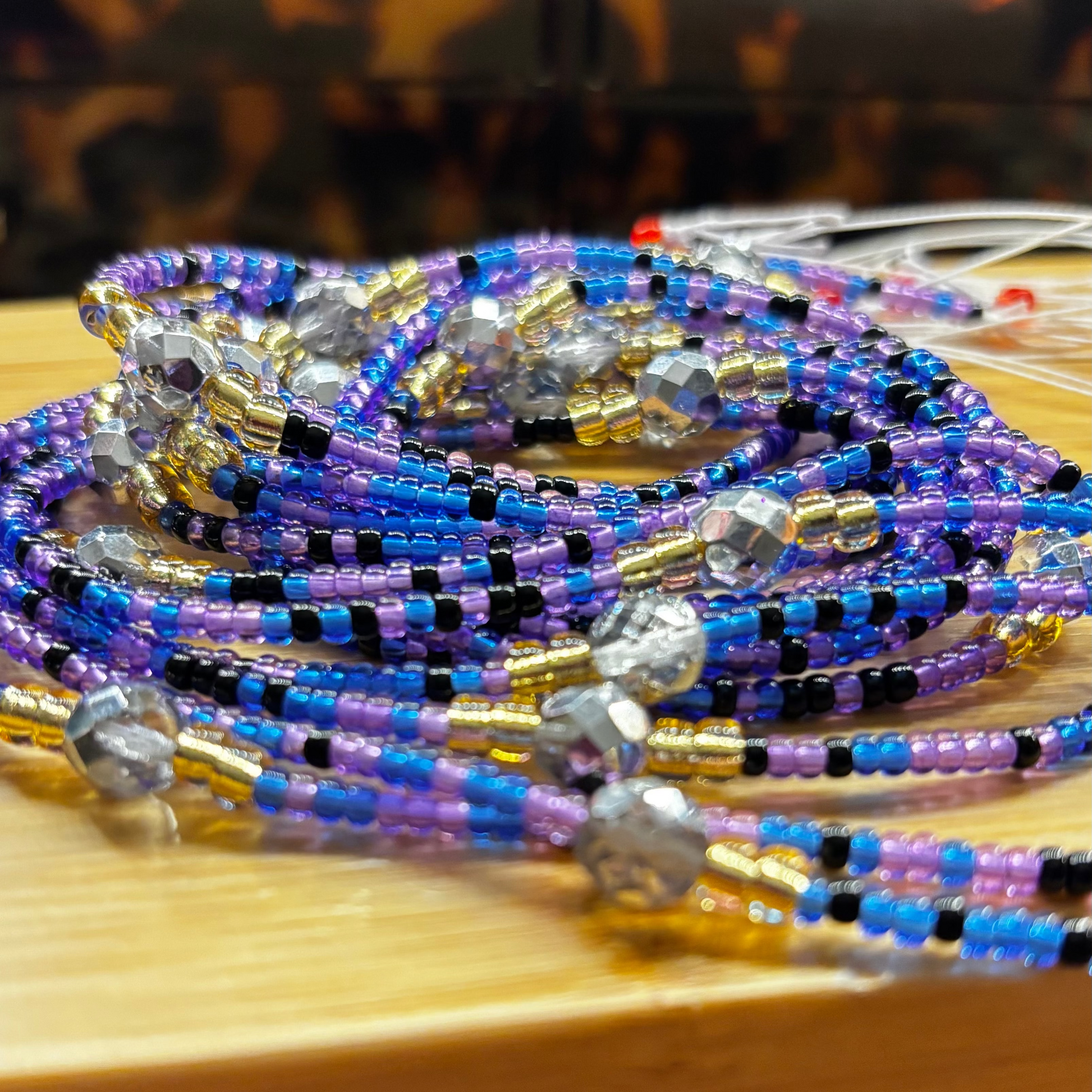 Colorful beaded bracelets on a wooden surface with a tortoiseshell-patterned background