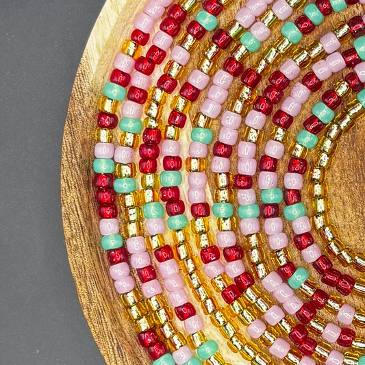 Handmade strawberry, light green and red pink waist beads with soft feminine tones designed for body adornment and self-love.